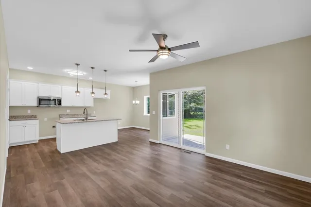 a large kitchen with cabinets wooden floor and stainless steel appliances