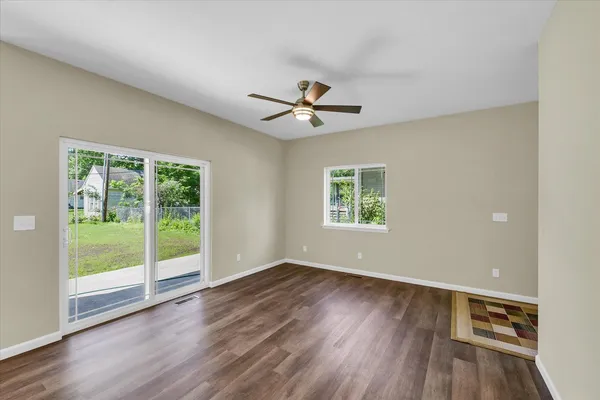 a view of a room with wooden floor and a ceiling fan