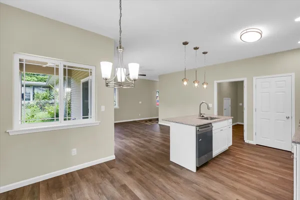 a kitchen with stainless steel appliances granite countertop a stove a sink and a chandelier