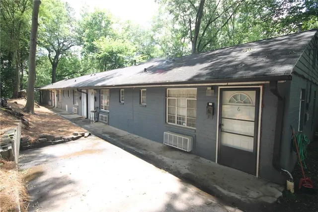 a backyard of a house with large trees and outdoor seating