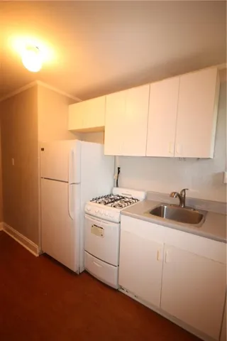 an empty room with wooden floor and a ceiling fan