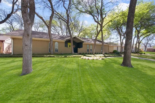 a view of a house with a yard and tree