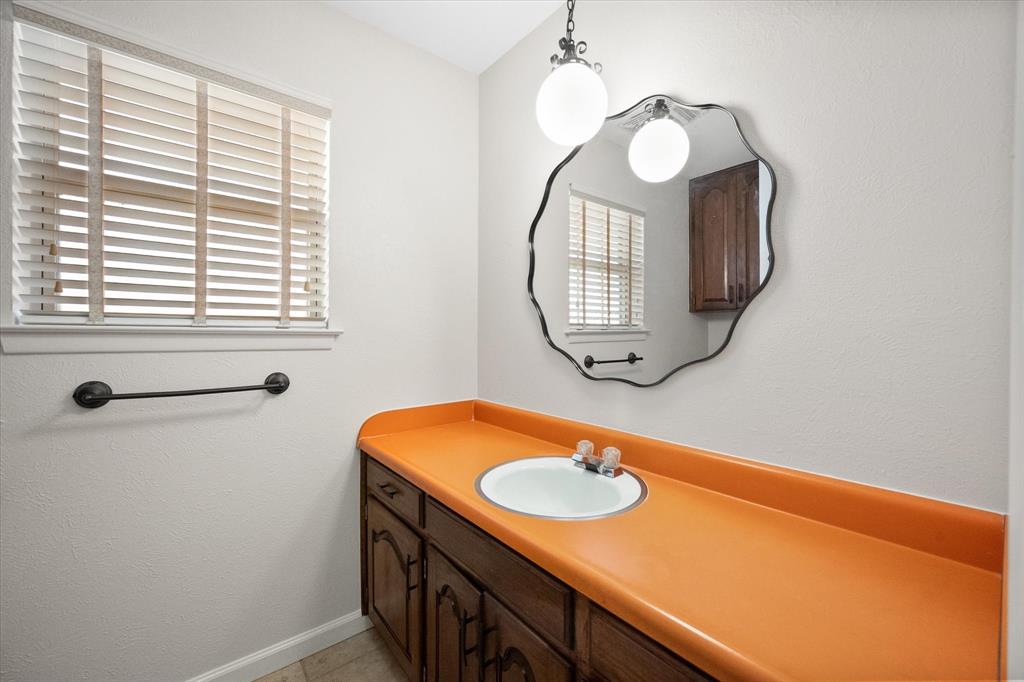 2003 Botts Drive Arlington, TX 76012 - Photo 34 of 40 a bathroom with a sink a mirror and a window