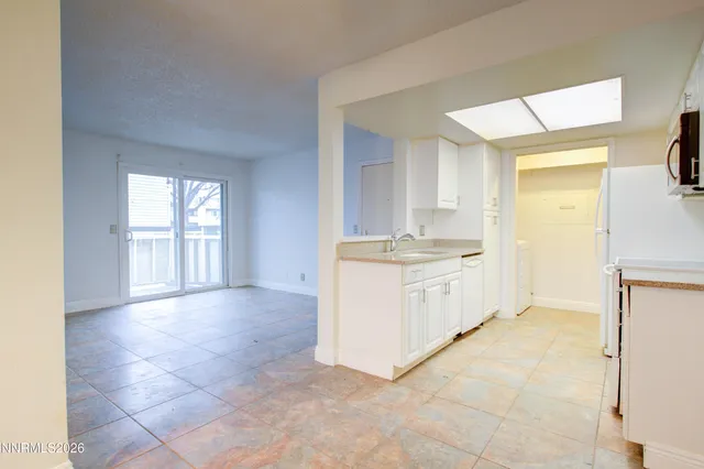 a view of kitchen with a sink cabinets and window
