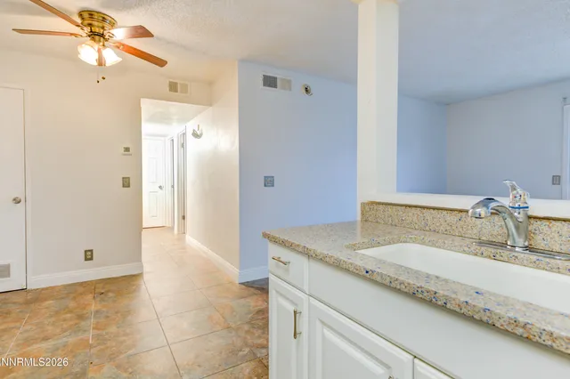 a bathroom with a granite countertop sink a mirror and a shower