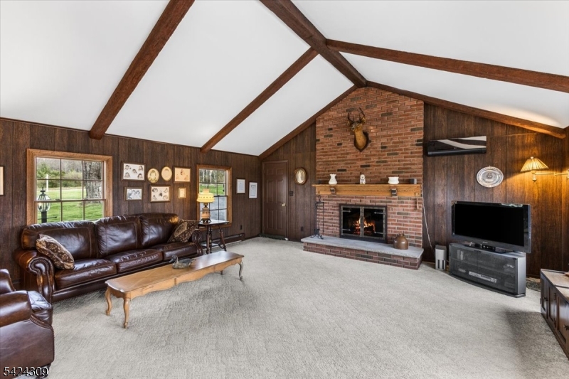 58 Andover Road Sparta, NJ 07871 - Photo 14 of 38 a living room with furniture a flat screen tv and a fireplace