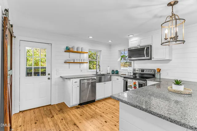 a kitchen with stainless steel appliances granite countertop a sink refrigerator and microwave