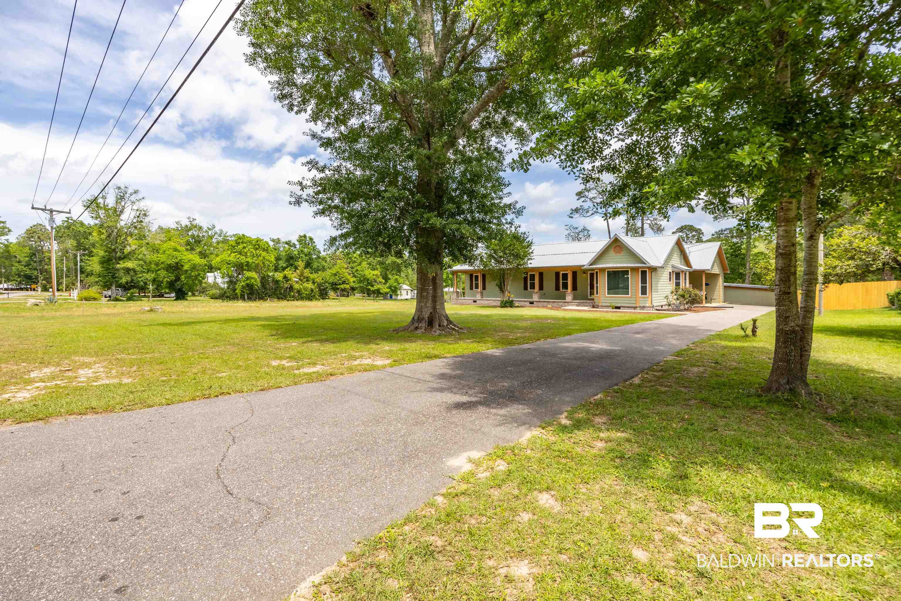 9771 Clarke Ridge Road Foley, AL 36535 - Photo 63 of 72 View of front of house featuring a front yard, covered porch, driveway, and fence.