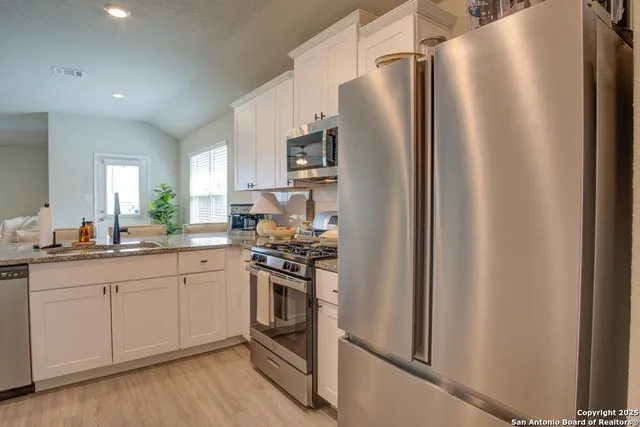 a kitchen with stainless steel appliances a refrigerator sink and stove