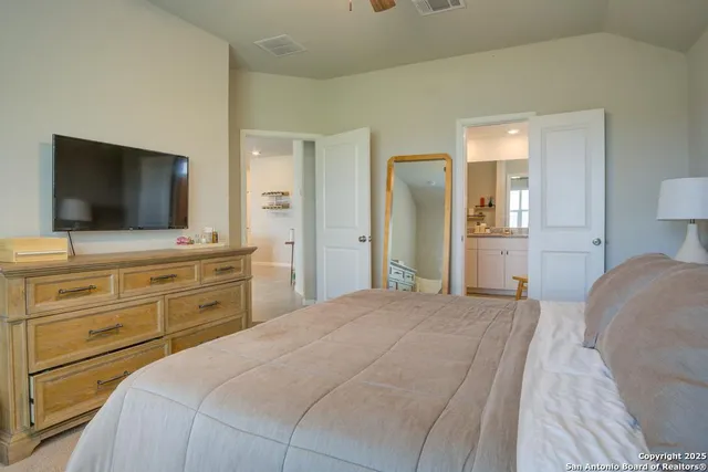 a bedroom with a bed and a flat screen tv in white walls