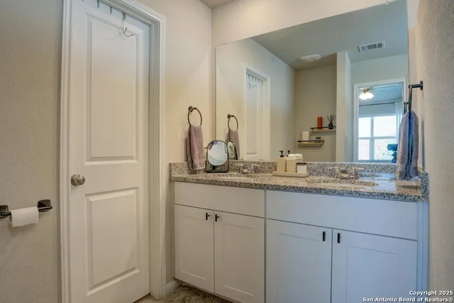 a bathroom with a granite countertop sink and a mirror