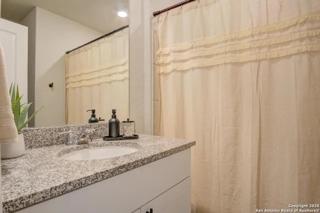 a bathroom with a granite countertop sink and vanity