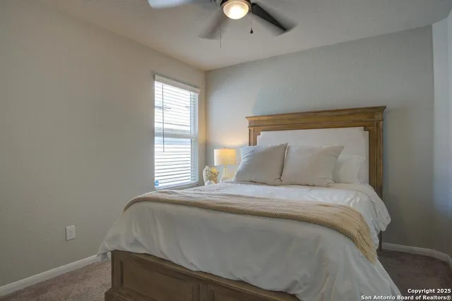 a large bed sitting in a bedroom next to a window and a chandelier