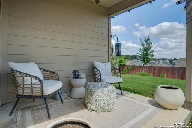 a couple of chairs sitting in patio with a yard