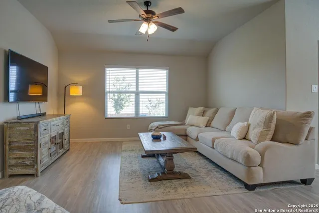 a living room with furniture a flat screen tv and a window