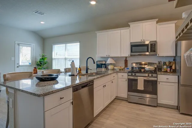 a kitchen with granite countertop a sink and steel appliances