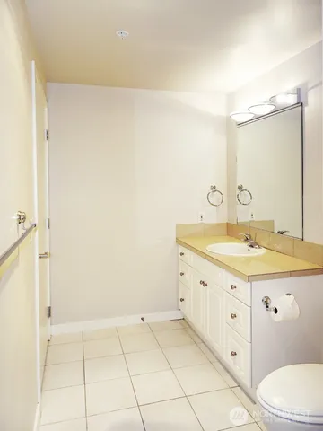a bathroom with a granite countertop sink a toilet and a mirror