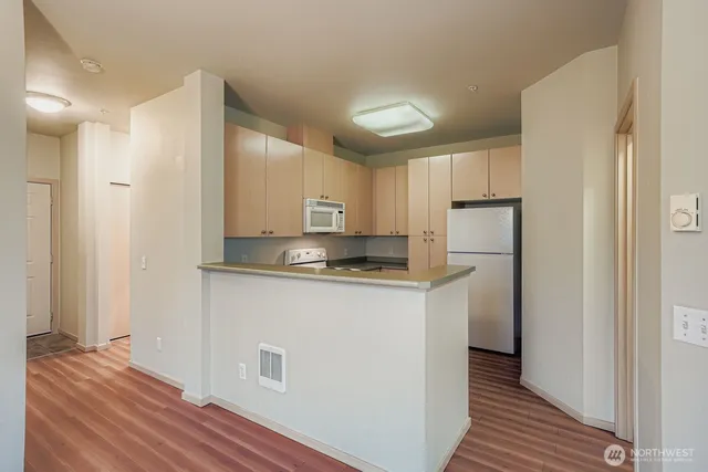 a kitchen with stainless steel appliances granite countertop a refrigerator and a stove