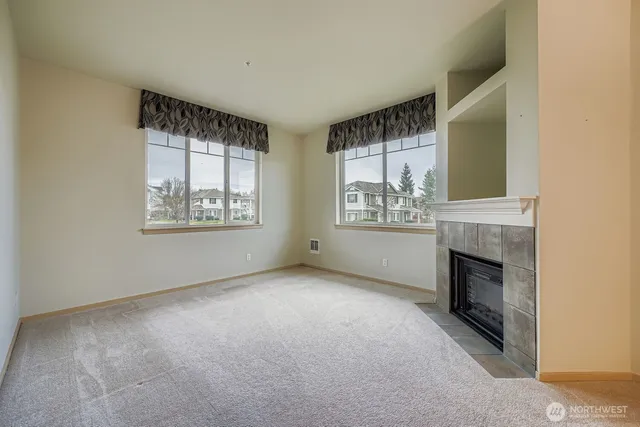 a view of an empty room with a fireplace and a window