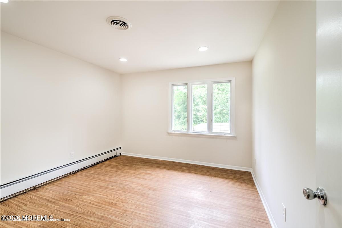 699 Aldrich Road Howell, NJ 07731 - Photo 15 of 23 wooden floor in an empty room with a window