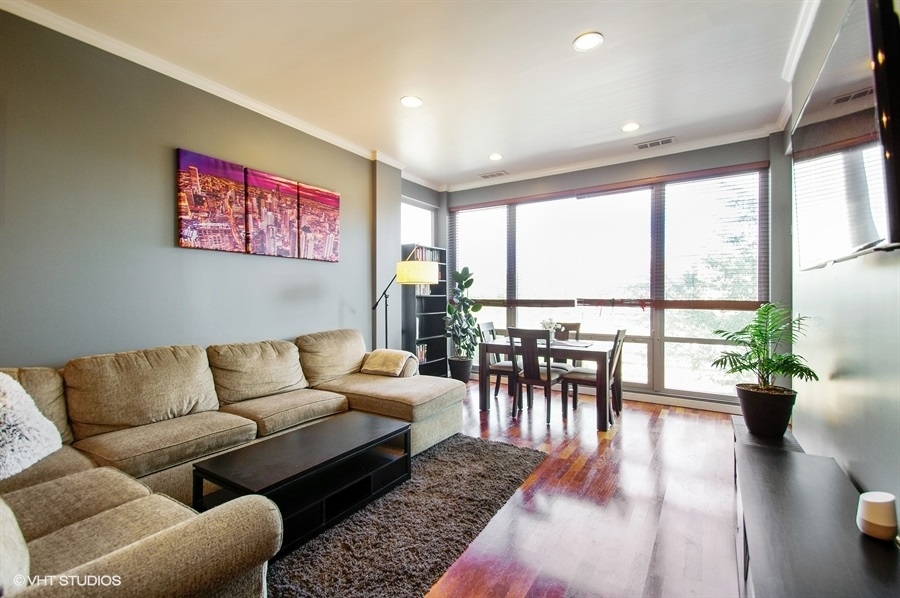 3920 North Sheridan Road, Unit 311 Chicago, IL 60613 - Photo 2 of 10 a living room with furniture and a large window