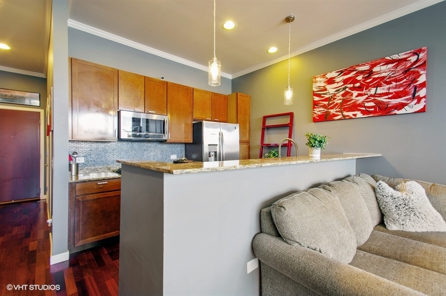 3920 North Sheridan Road, Unit 311 Chicago, IL 60613 - Photo 4 of 10 a living room with stainless steel appliances furniture and a kitchen view