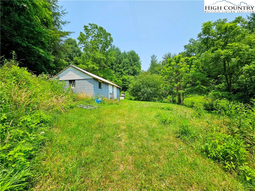 785 West Deep Ford Road Lansing, NC 28643 - Photo 18 of 21 a yellow house with lots of trees in the background