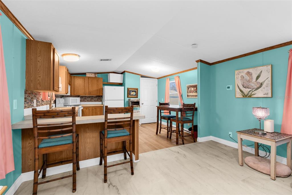 6128 Padula Street Punta Gorda, FL 33950 - Photo 5 of 24 a kitchen with a dining table chairs and a refrigerator