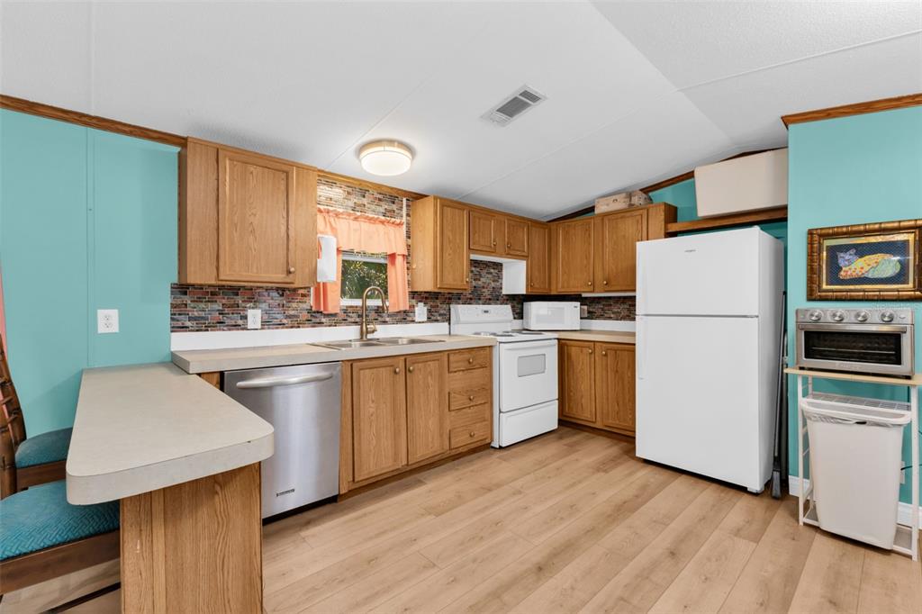 6128 Padula Street Punta Gorda, FL 33950 - Photo 7 of 24 a kitchen with granite countertop white cabinets and white appliances