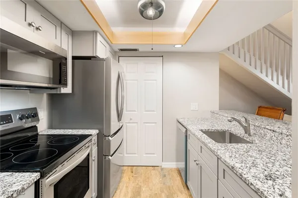 a kitchen with granite countertop a sink stainless steel appliances and cabinets