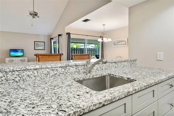 a kitchen with a granite countertop sink and a large mirror