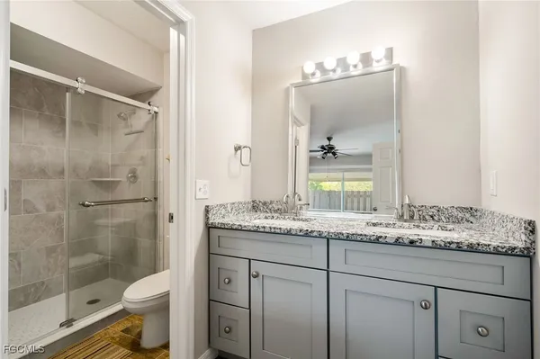 a bathroom with a granite countertop sink toilet and shower