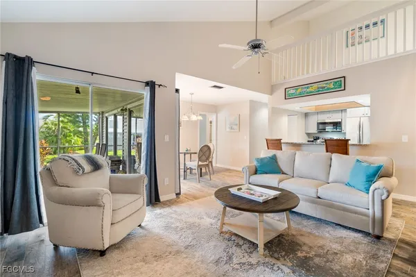 a living room with furniture a large window and a chandelier