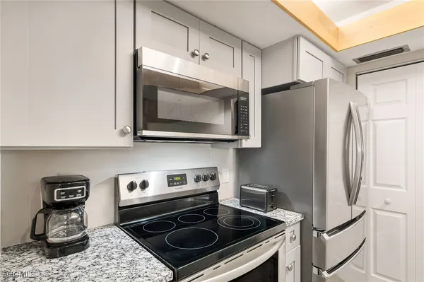 a kitchen with stainless steel appliances granite countertop a stove microwave and refrigerator