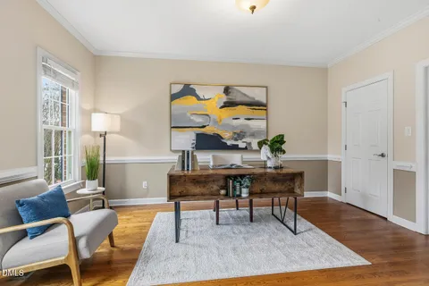 a view of a workspace room with wooden floor and furniture