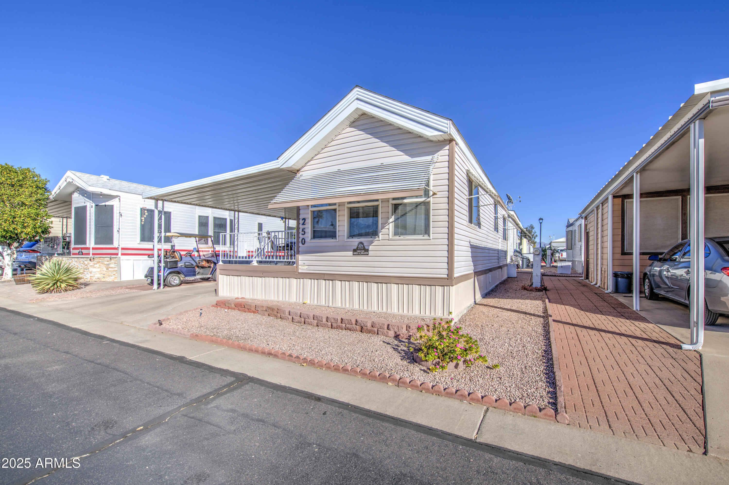 7750 East Broadway Road, Unit 250 Mesa, AZ 85208 - Photo 19 of 35 a view of a white house with large windows and a small yard