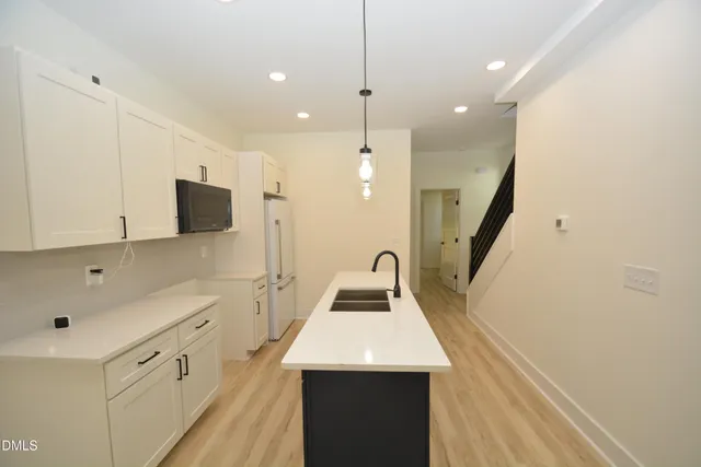 a kitchen with white cabinets and sink