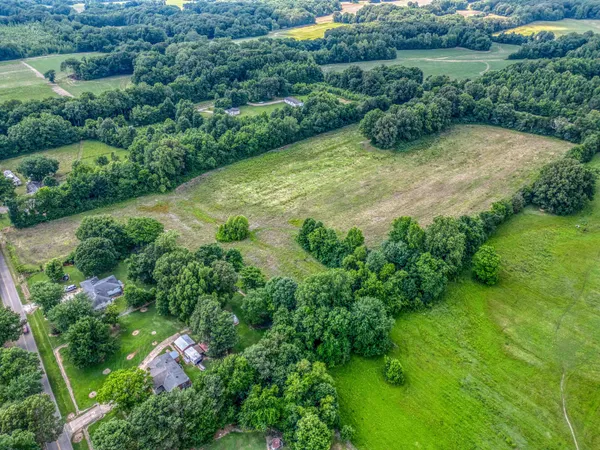 an aerial view of residential house with outdoor space and trees all around