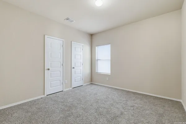 an empty room with windows and closet