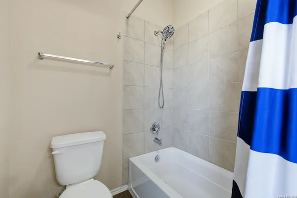 a white toilet sitting next to a bath tub