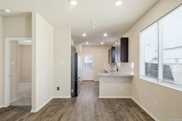 a kitchen with stainless steel appliances kitchen island granite countertop a refrigerator and a sink