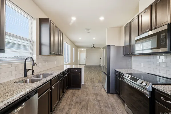 a kitchen with stainless steel appliances granite countertop a sink stove and refrigerator