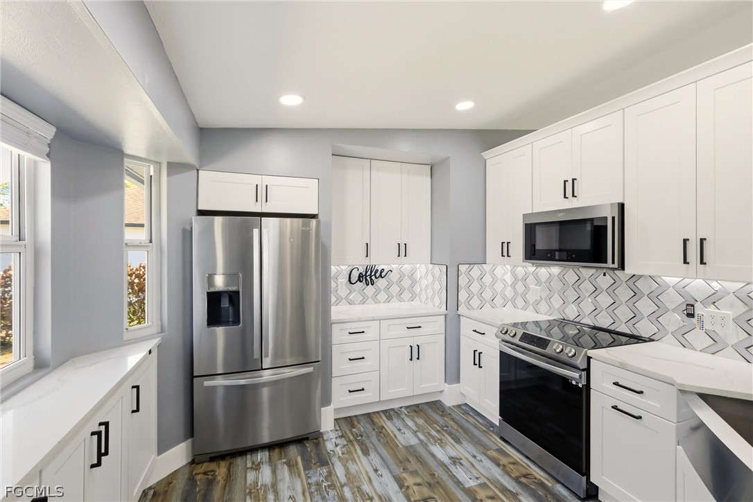 3404 2nd Street Southwest Lehigh Acres, FL 33976 - Photo 13 of 41 a kitchen with stainless steel appliances a refrigerator stove and microwave
