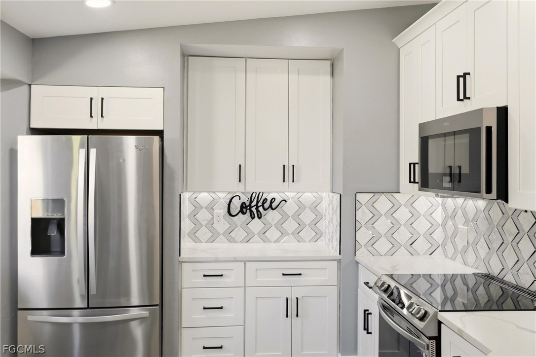 3404 2nd Street Southwest Lehigh Acres, FL 33976 - Photo 14 of 41 a view of kitchen with white cabinets and refrigerator