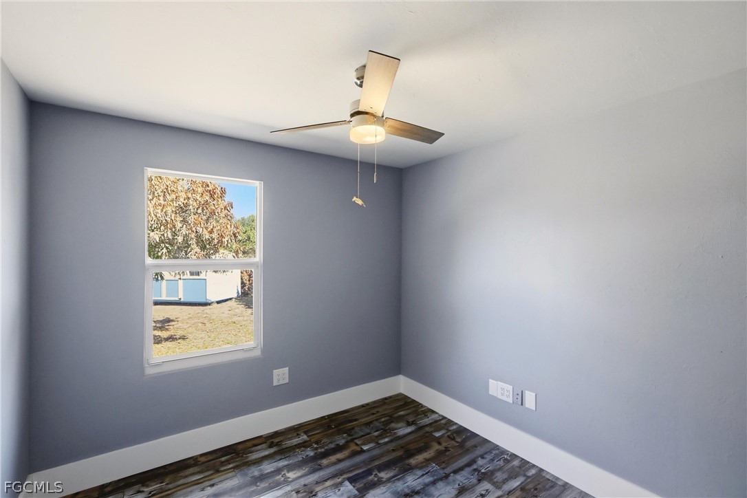 3404 2nd Street Southwest Lehigh Acres, FL 33976 - Photo 23 of 41 a view of an empty room with wooden floor and a window