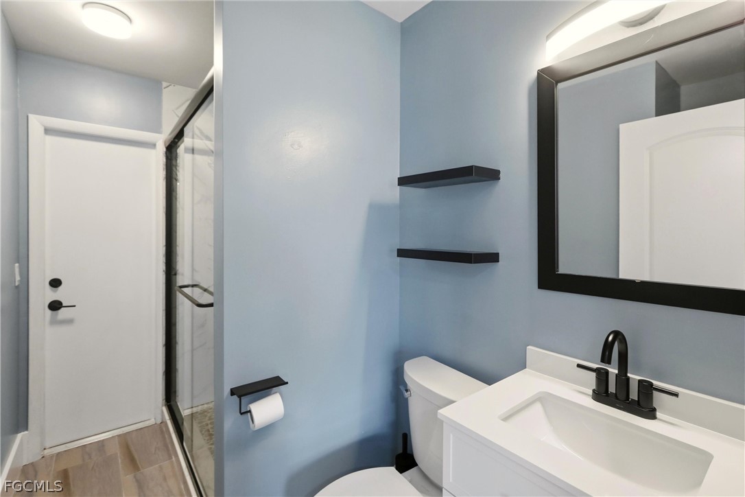 3404 2nd Street Southwest Lehigh Acres, FL 33976 - Photo 26 of 41 a bathroom with a toilet sink and mirror