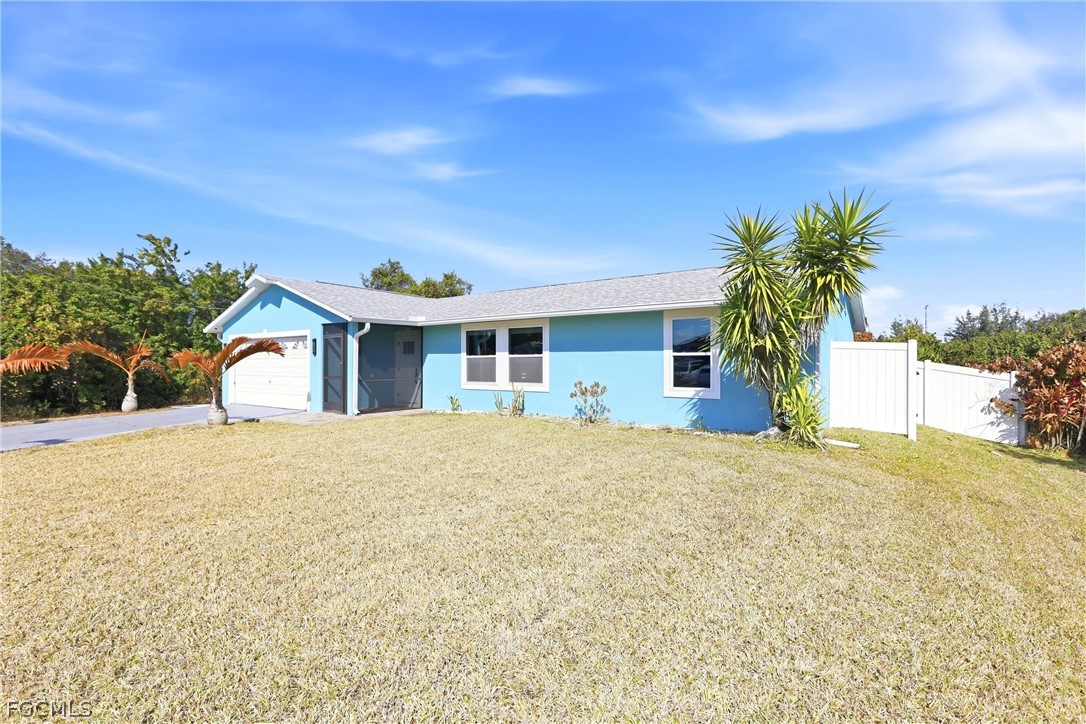 3404 2nd Street Southwest Lehigh Acres, FL 33976 - Photo 6 of 41 a front view of a house with a yard and garage
