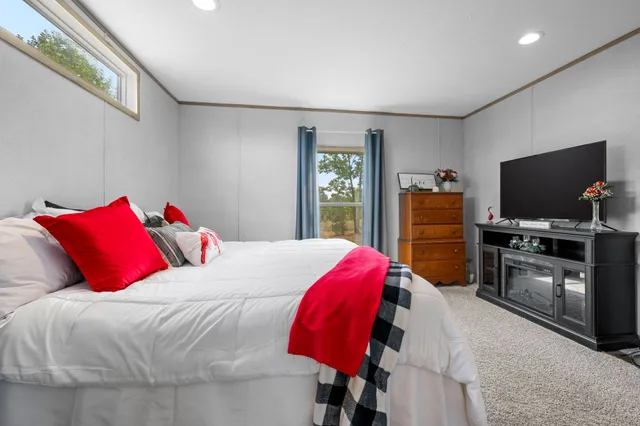 a bedroom with a bed and a flat screen tv