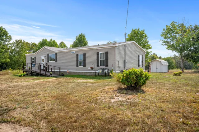 a view of a house with backyard and sitting area