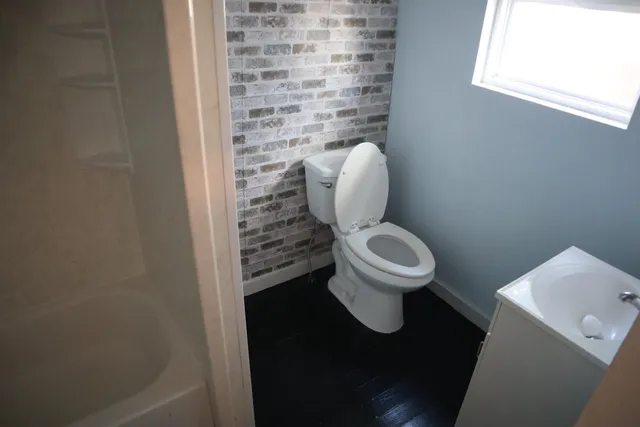 a white toilet sitting next to a shower